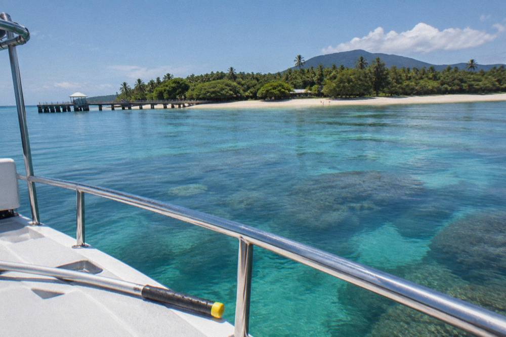 Calm tropical open water beyond a boat rail on the outer reef line