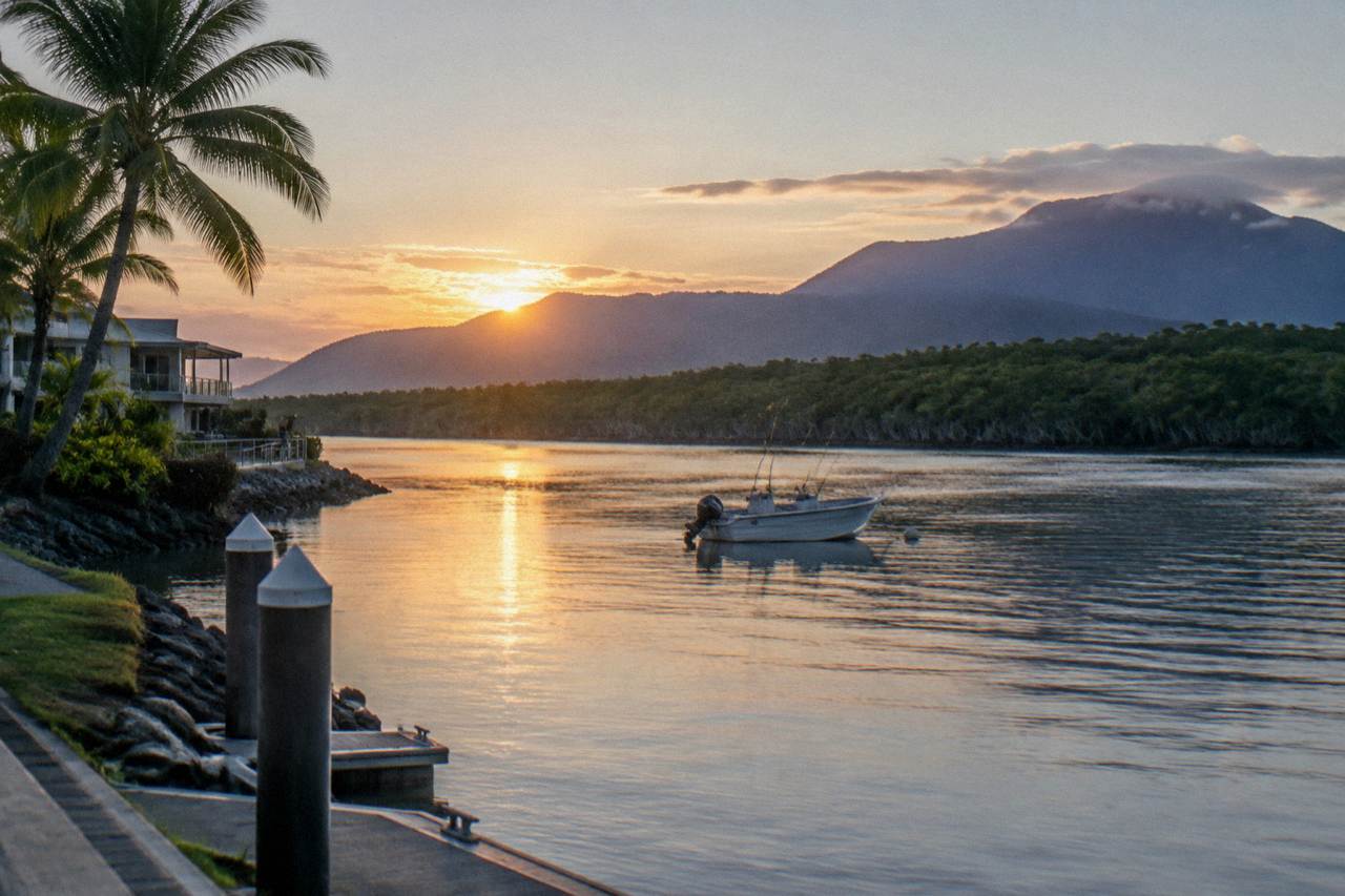 Calm tropical inlet water near Cairns at sunrise with mangroves along the shore