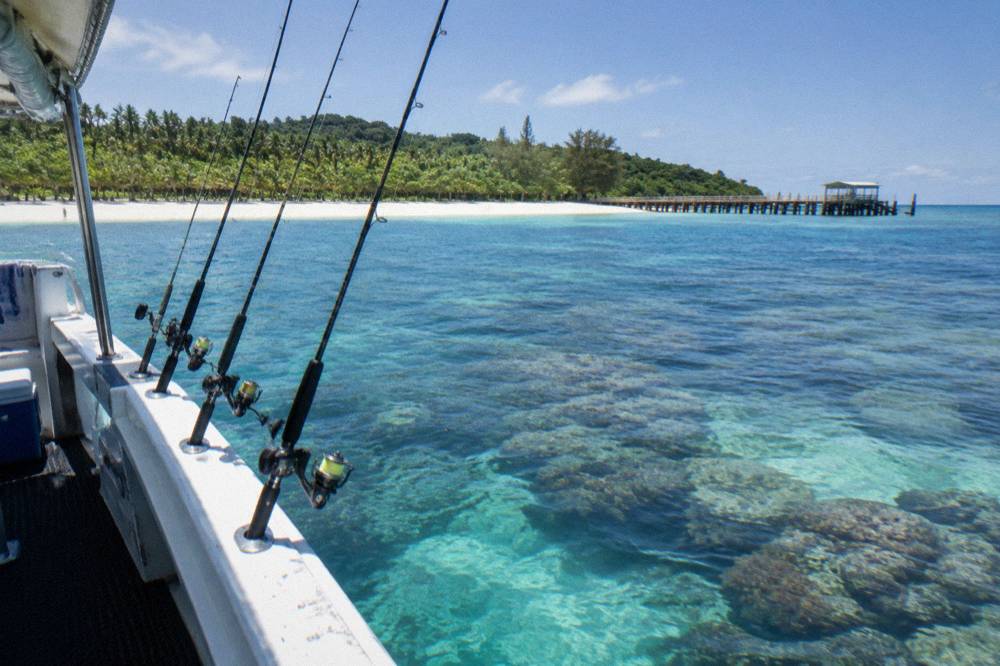 Coral reef water seen from a boat with fishing rods in holders