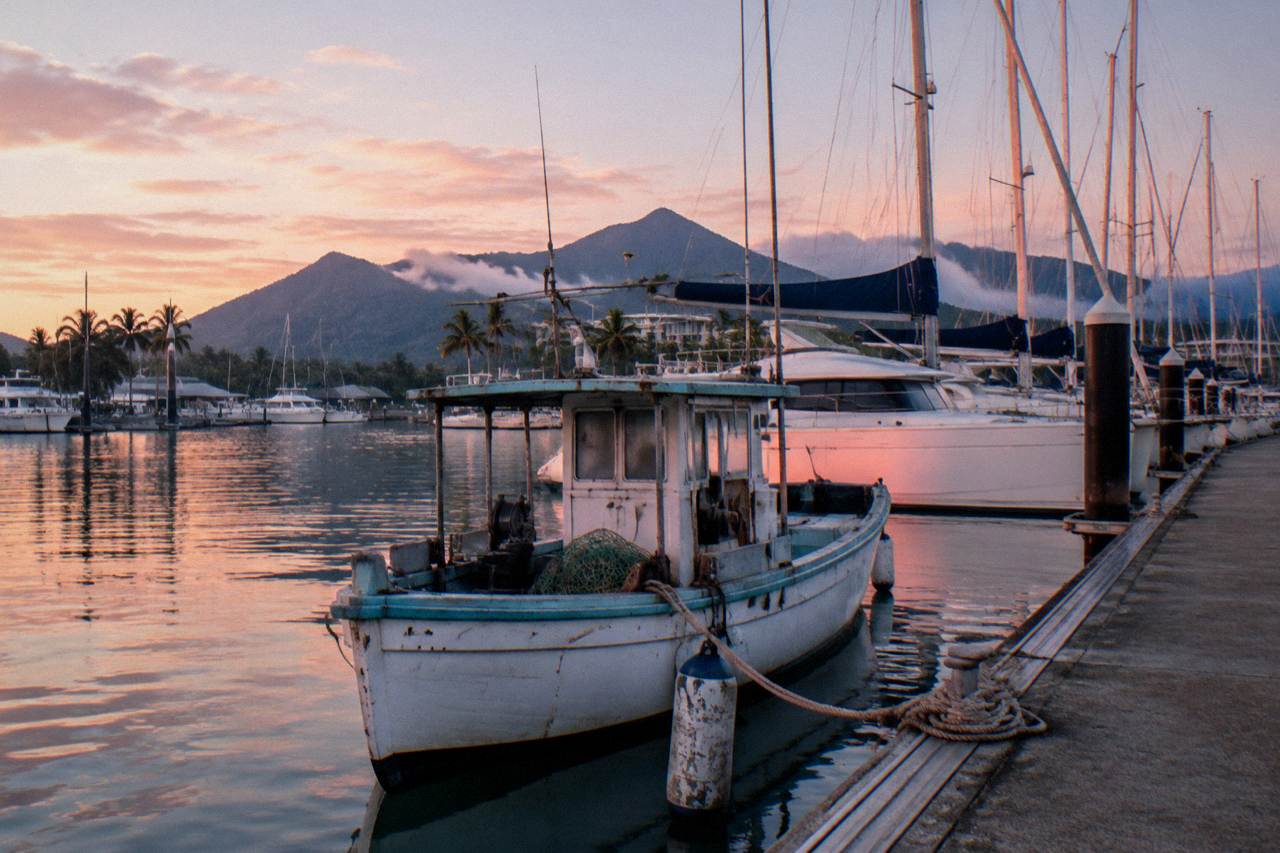Small fishing boat moored at a tropical marina in the early morning light
