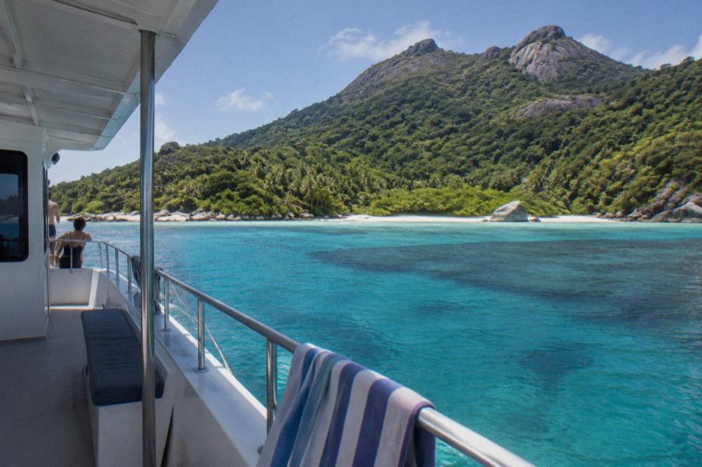Fishing boat anchored near a tropical reef in clear blue water