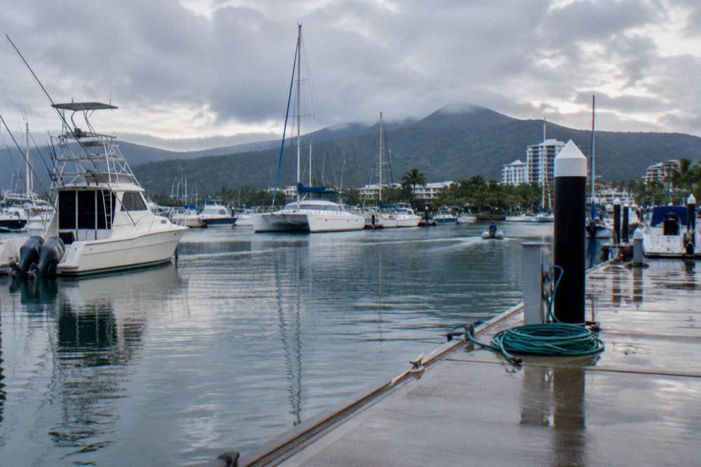 A calm tropical morning over Cairns water with boats at anchor near the marina