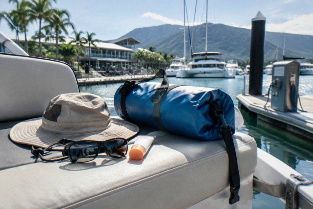 Sunscreen, hat, sunglasses and a small dry bag arranged on a boat seat